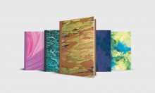 Five journals with abstract designs on the cover: pink, green, yellow and blue.